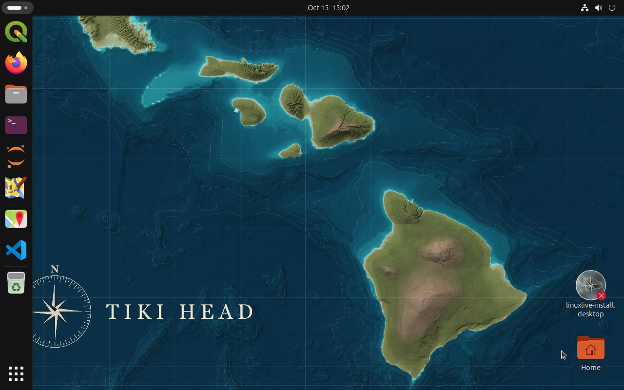 The Tiki Head GNOME desktop: a dock on the left with QGIS, Firefox, Files, Terminal, Jupyter, JOSM, Maps and Visual Studio Code, over a dark blue nautical chart of the Hawaiian Islands with a compass rose and the words Tiki Head.